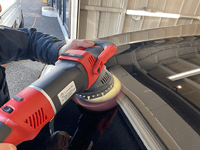 ボンネットをポリッシャーで磨いている